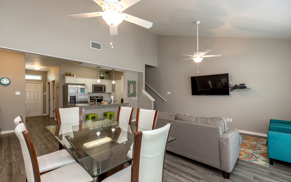 Relax in your spacious open-concept living area with comfortable seating, elegant dining table, and modern kitchen—perfect for memorable meals together.