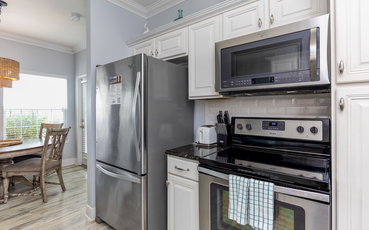 Your fully equipped kitchen awaits with stainless steel appliances, granite counters, and crisp white cabinetry for memorable meal preparation.