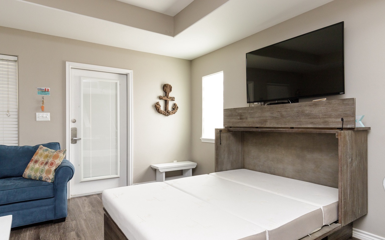 Your nautical-themed room features a wall bed and comfy seating area, perfect for relaxing after coastal adventures.