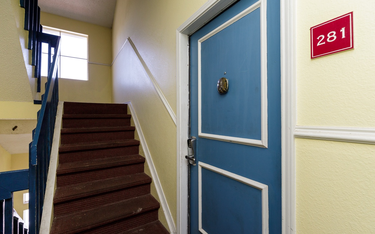 A welcoming entrance hallway with charming blue door and clear room number guides you home after exploring.