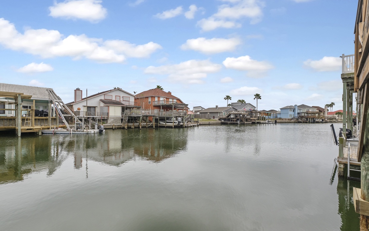 Waterfront community with canal homes, private docks, and peaceful waters under cloudy skies.