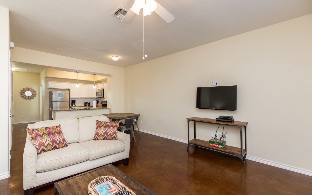 Unwind in your bright living space with a comfy sofa, flat-screen TV, and open kitchen - perfect for relaxing after exploring.