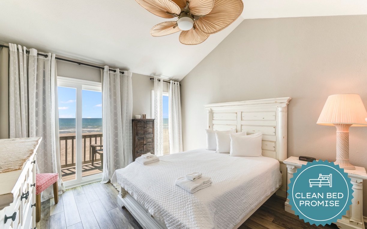 Wake up to ocean waves through your private balcony doors in this serene coastal bedroom with crisp linens and tropical charm.