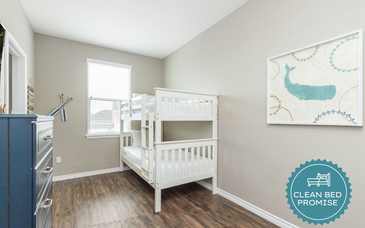 Your kids will love this cheerful bunk bed room with whimsical whale artwork and plenty of space for bedtime stories.