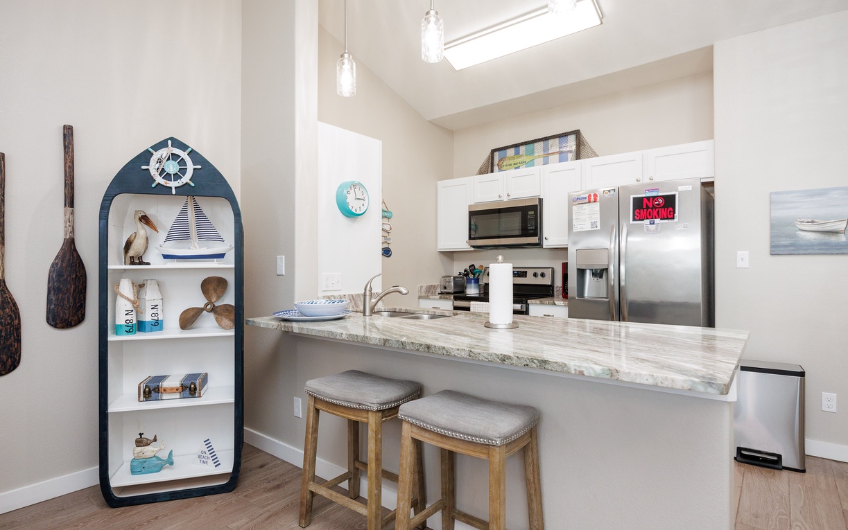 Your bright kitchen invites morning coffee sessions at the breakfast bar, while nautical touches add coastal charm to your culinary adventures.