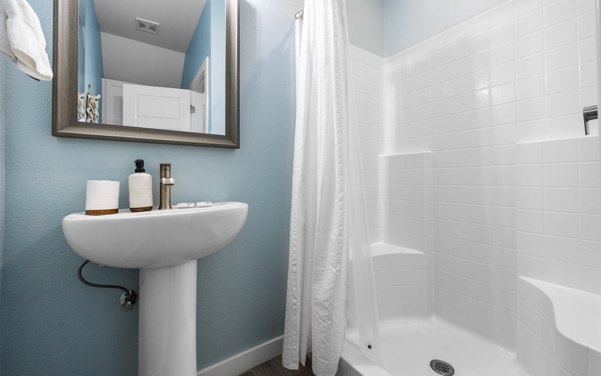 Refresh in your bright, clean bathroom featuring a spacious shower and modern amenities for a comfortable stay.