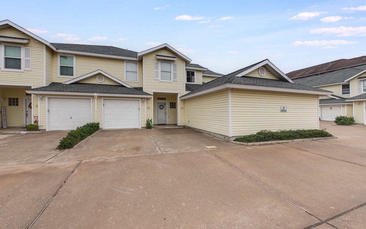 Modern townhome complex with convenient parking and well-maintained grounds in a peaceful residential neighborhood setting.