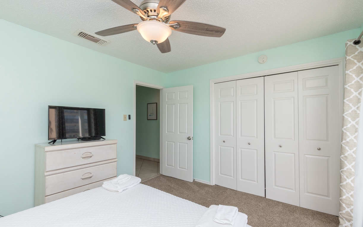 Relax in your peaceful mint-green bedroom with a ceiling fan keeping you cool and ample closet space for all your belongings.