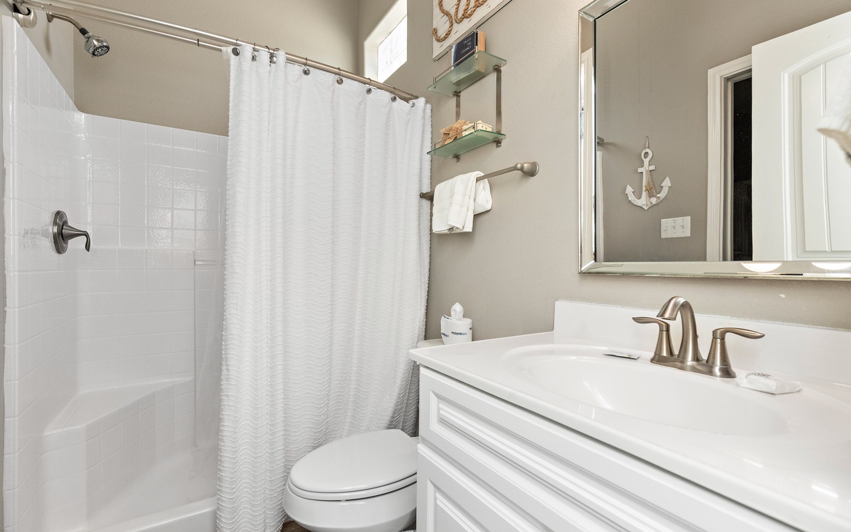 Step into your pristine bathroom with elegant coastal touches, featuring a spacious shower and charming nautical details that make your morning routine feel refreshing.