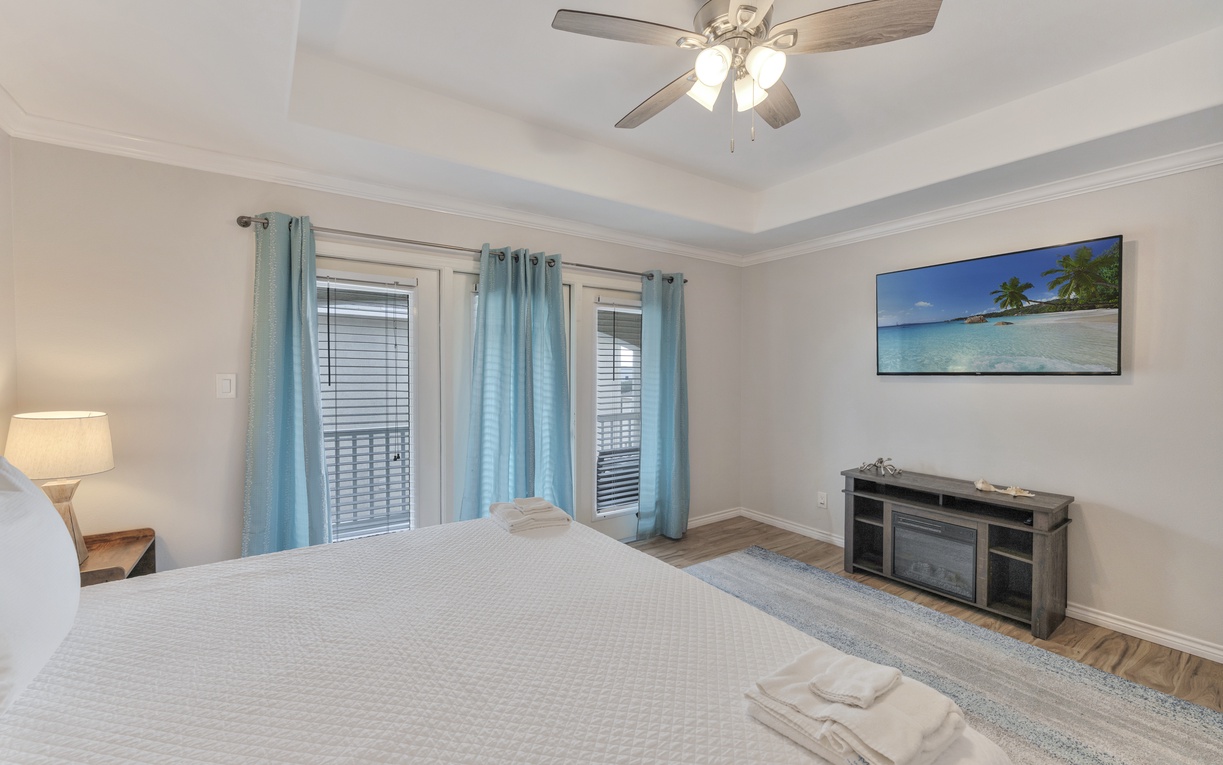 Drift off to sleep beneath the gentle ceiling fan in your serene bedroom, complete with coastal artwork and cozy furnishings.