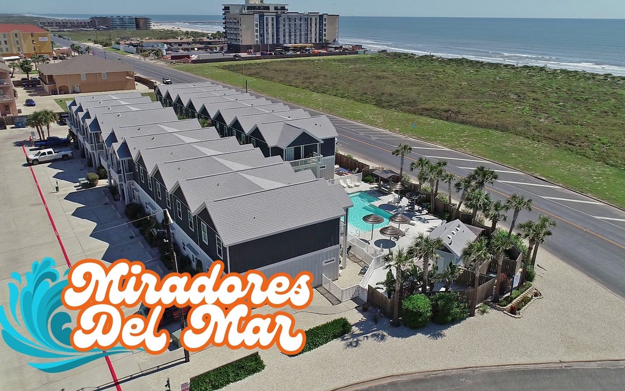 Aerial view of beachfront townhomes with pool amenities, perfectly positioned between ocean and coastal convenience.