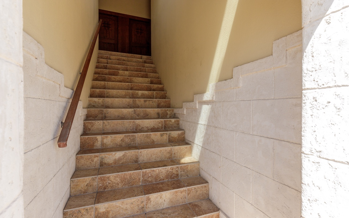 Stone steps lead you upward through this charming stairwell, where natural light filters in to illuminate your path home.