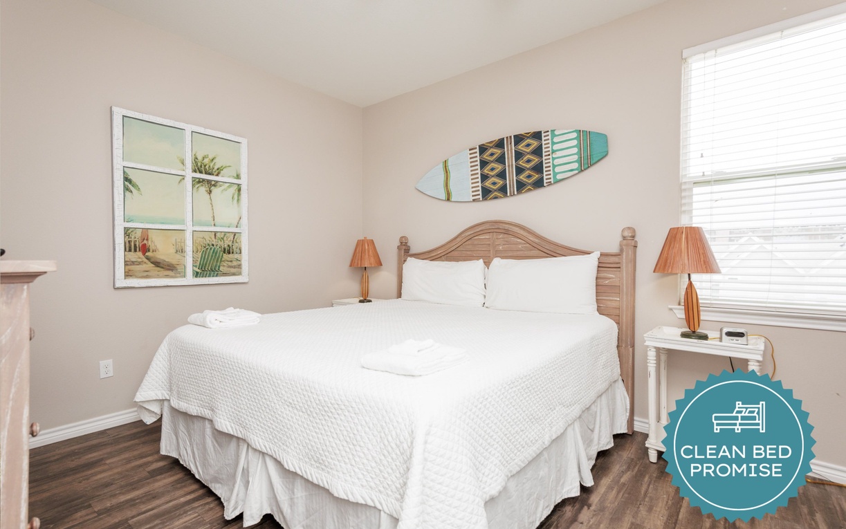 Sink into crisp white linens in your coastal-themed bedroom, where natural light flows through windows and beach-inspired décor creates a peaceful retreat.