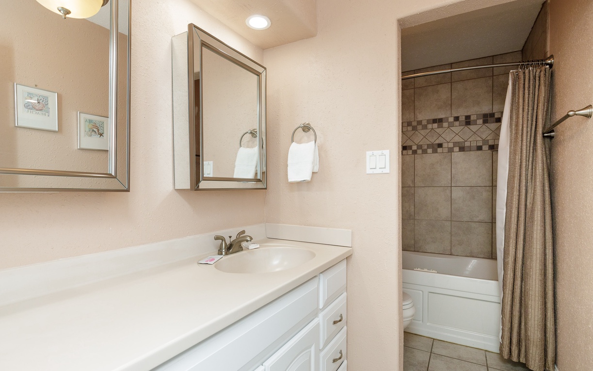 Your spacious bathroom features clean white counters, elegant tiled shower, and everything you need to refresh after your adventures.