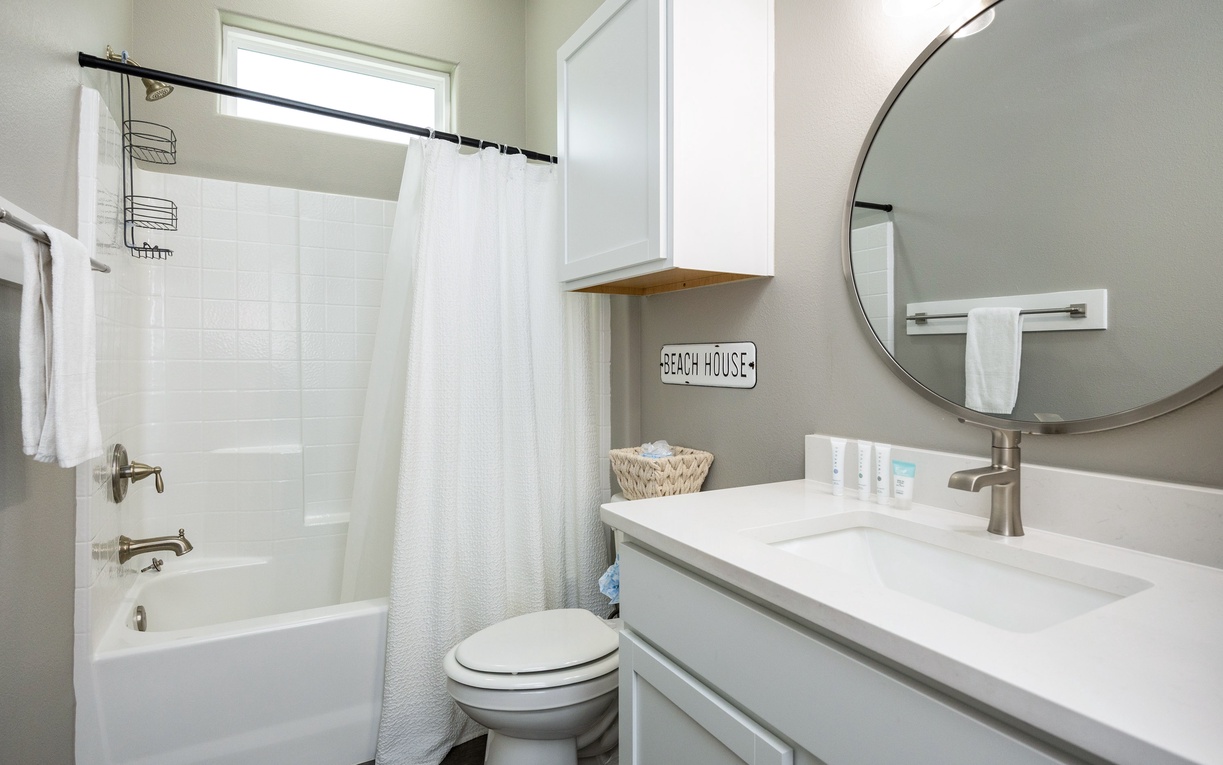 Refresh in your bright, beautifully updated bathroom with modern vanity, rainfall shower, and coastal charm touches.