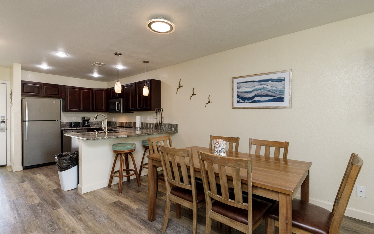 Your open kitchen and dining area blends modern convenience with coastal charm, perfect for preparing meals and gathering with loved ones.