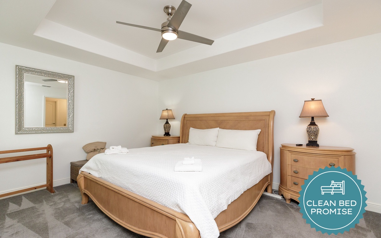 Unwind in your peaceful bedroom with crisp linens, warm lighting, and a gentle ceiling fan for perfect comfort.