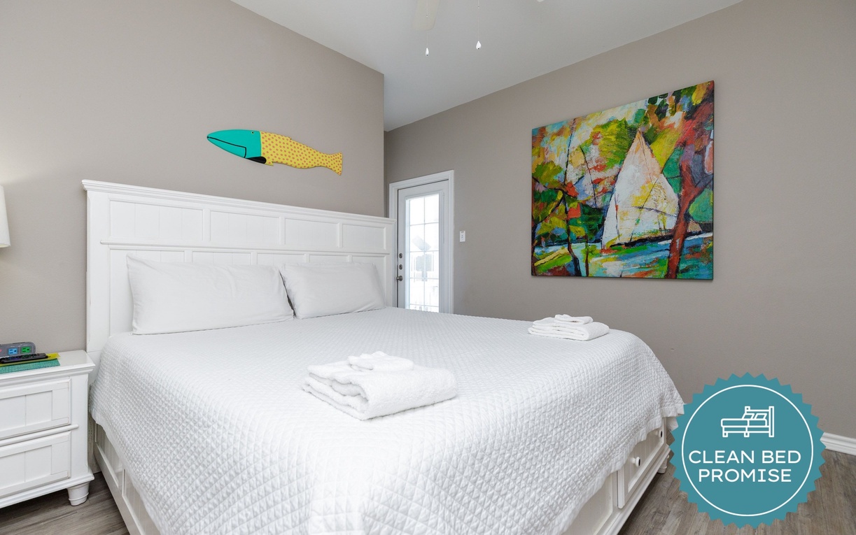 Your comfortable bedroom awaits with crisp linens and cheerful coastal artwork creating a peaceful retreat.