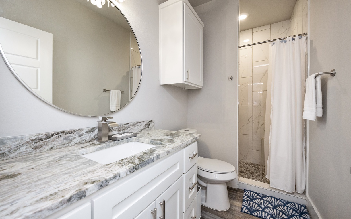 Refresh in your stylish bathroom featuring elegant marble countertops, modern fixtures, and a spacious walk-in shower with premium amenities.