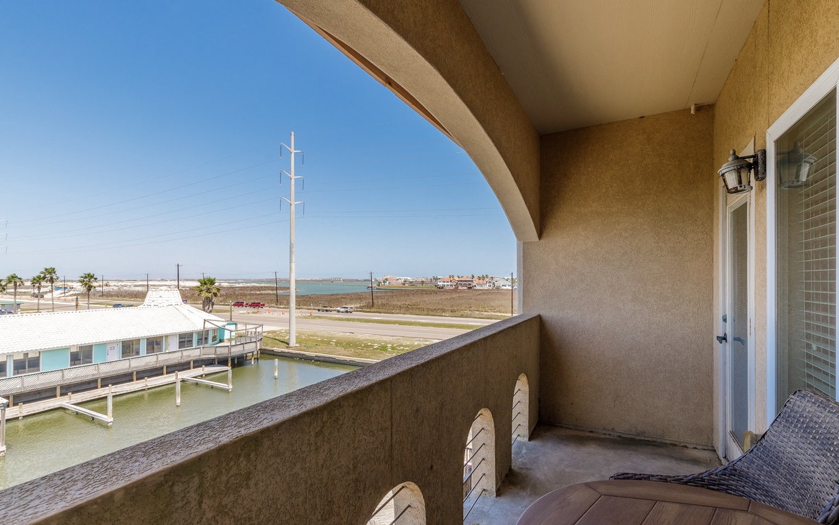 Covered balcony with waterfront views overlooking the coastal community and marina below.