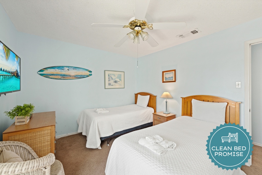 Settle into this inviting coastal bedroom featuring two twin beds, cheerful beach-inspired décor, and a comfortable space to relax after a day of fun.