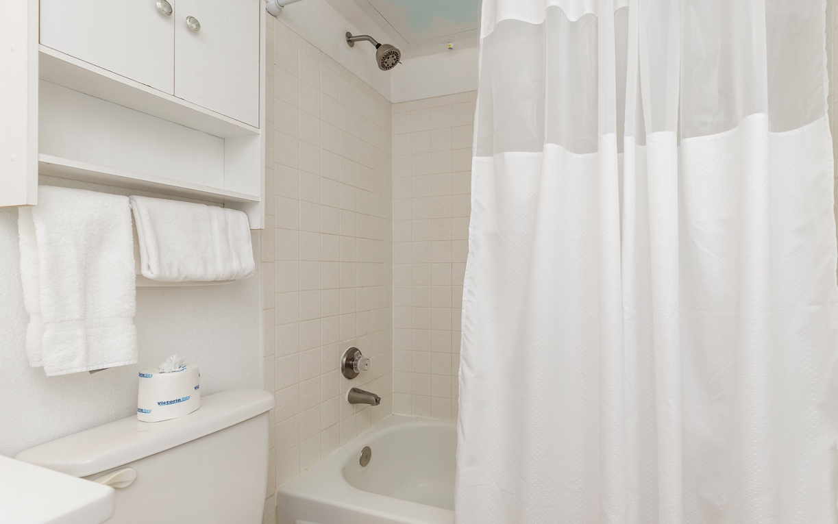 Step into your private bathroom featuring a full tub-shower combo with fresh towels and amenities waiting for your relaxing retreat.