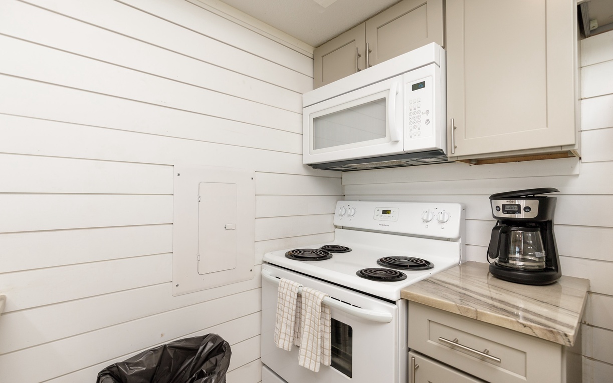 Your fully equipped kitchen awaits with modern appliances and charming shiplap walls, perfect for brewing morning coffee or preparing meals.