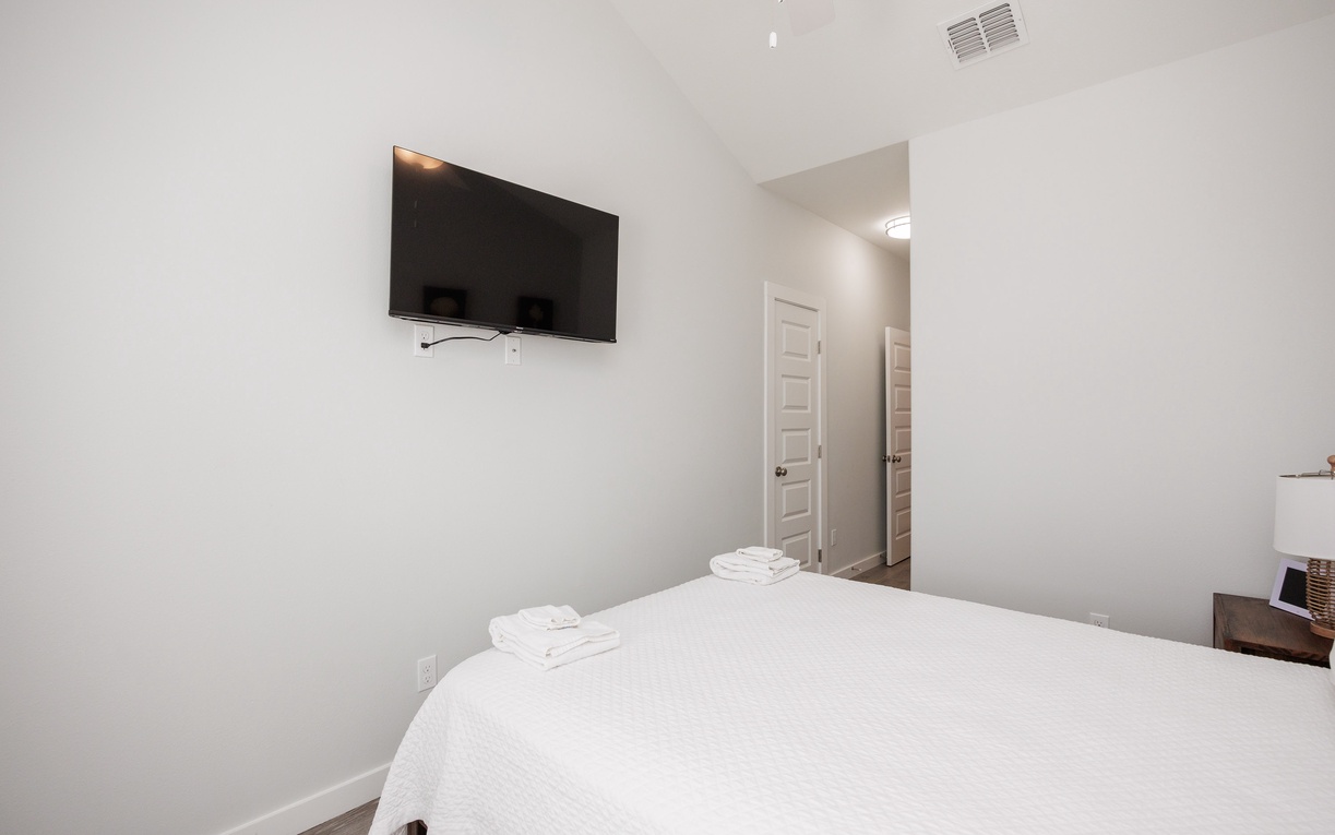 Unwind in your serene bedroom with crisp linens and wall-mounted TV for your entertainment.