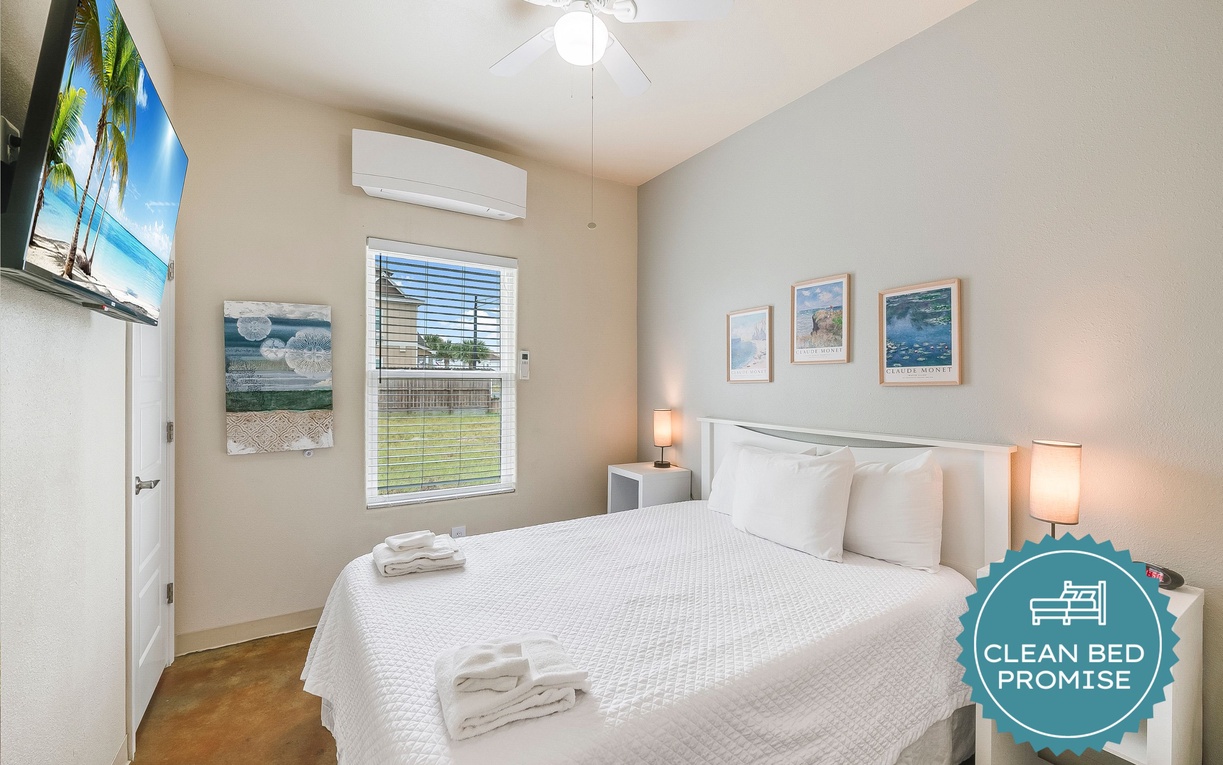 You'll sleep soundly in this bright, serene bedroom featuring crisp linens, gentle lighting, and tropical artwork.