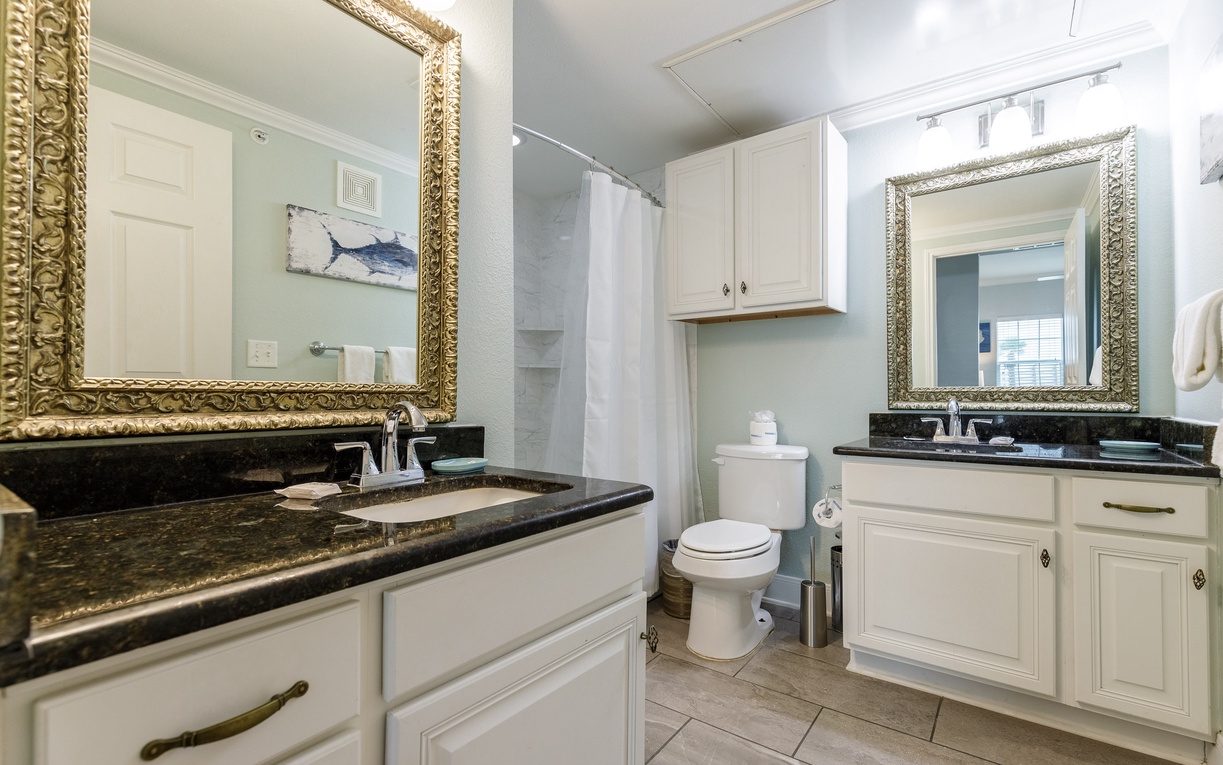 Step into your luxurious bathroom featuring dual vanities with elegant granite countertops and ornate gold mirrors that add glamour to your daily routine.