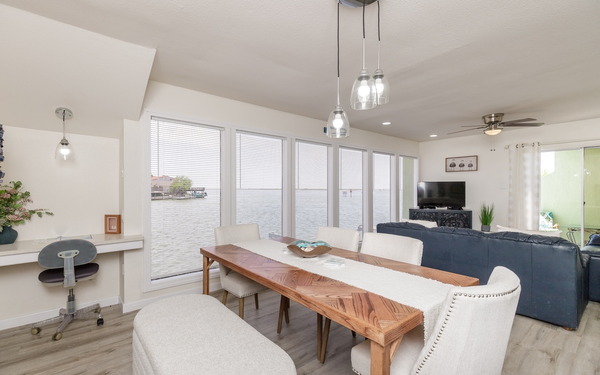 Your waterfront retreat features an open living space with stunning lake views through floor-to-ceiling windows, perfect for relaxing after exploring.