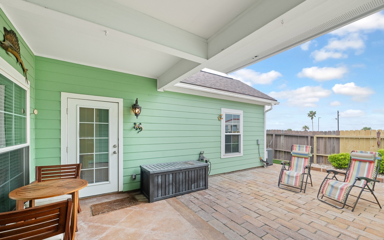 Your private patio welcomes relaxation with comfortable seating and charming coastal views under endless blue skies.