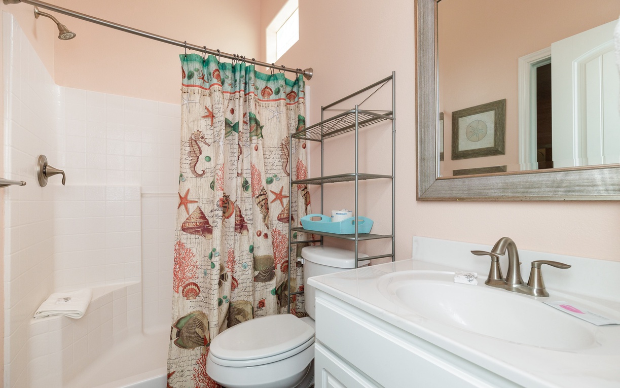 Step into your coastal-themed bathroom with convenient shower-tub combo and charming nautical touches that make getting ready a delight.