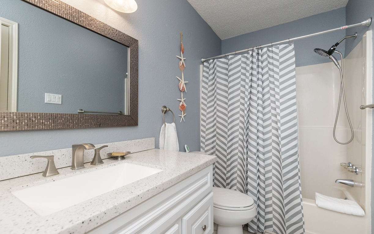 Refresh in your stylish bathroom with modern fixtures, soothing blue walls, and a sparkling clean tub-shower combo perfect for unwinding.