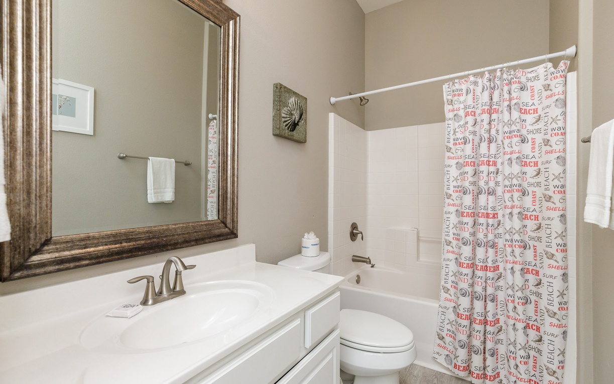 Refresh in your pristine bathroom with beach-themed touches and a large mirror that adds elegance to your morning routine.