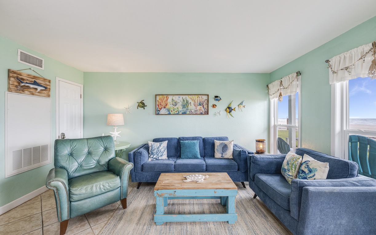 Sink into coastal comfort in your spacious living room featuring ocean-themed décor, plush seating, and serene sea-glass walls.