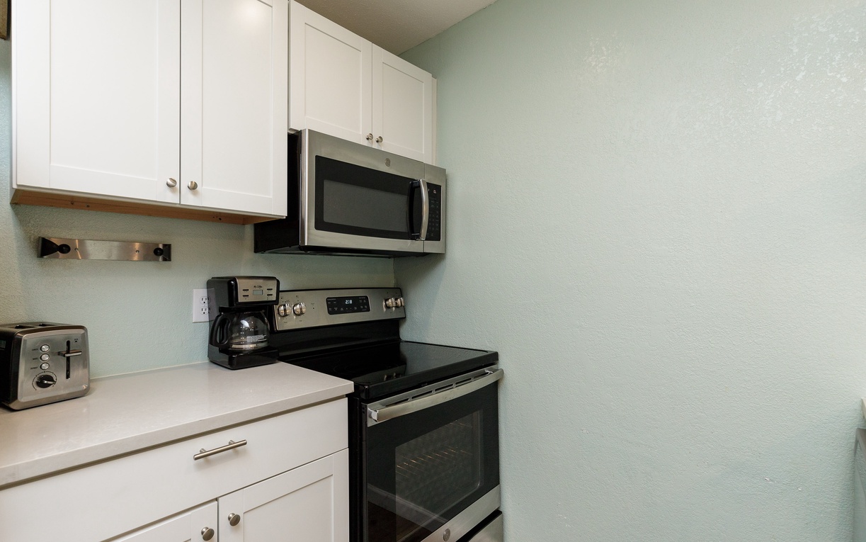 Your fully equipped kitchen features crisp white cabinets, stainless steel appliances, and a bright, welcoming atmosphere for cooking memorable meals.