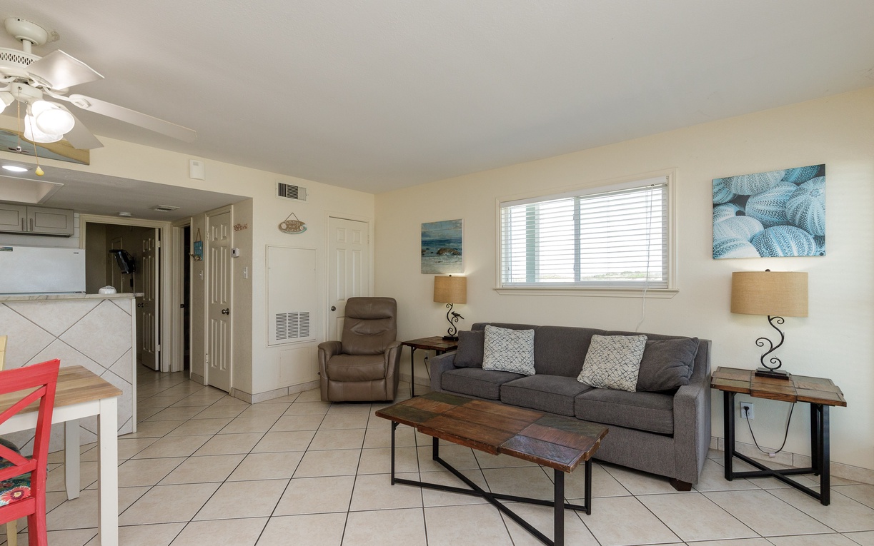 Unwind in your comfortable living room with coastal touches and natural light streaming through windows.