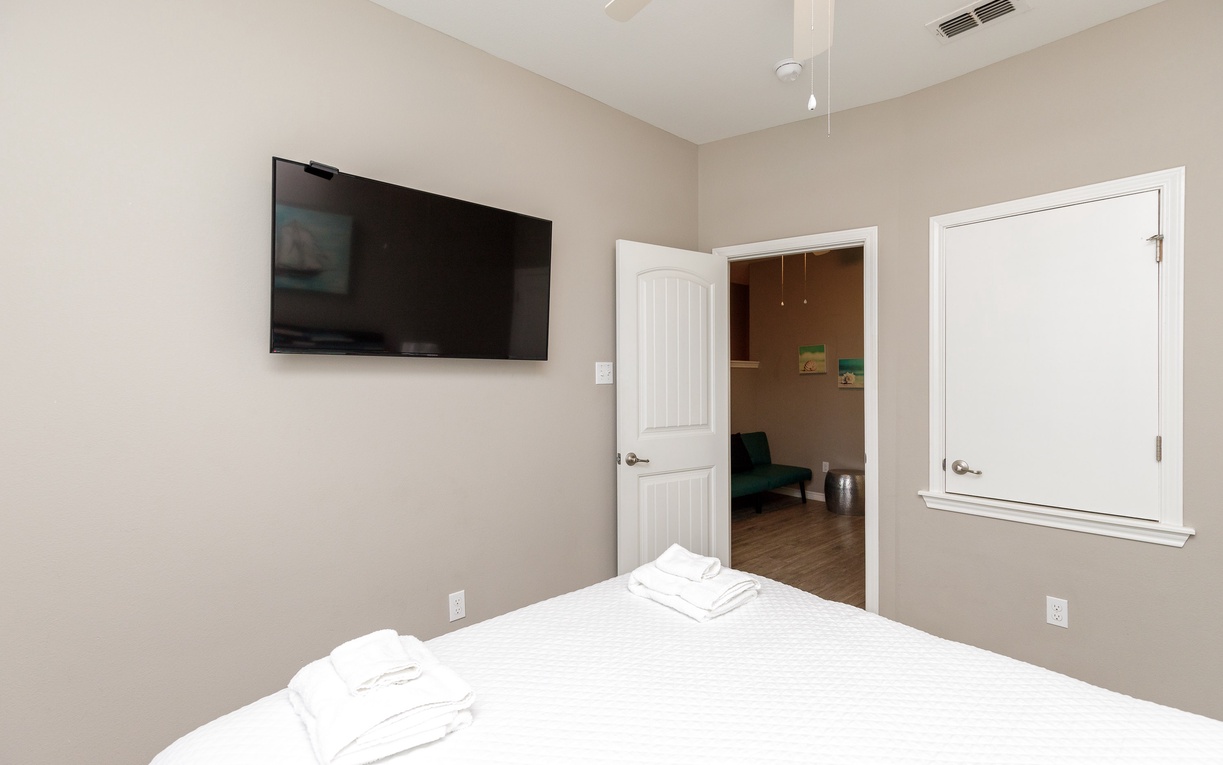 Your peaceful bedroom features a wall-mounted TV and soft neutral tones, perfect for unwinding after your adventures.