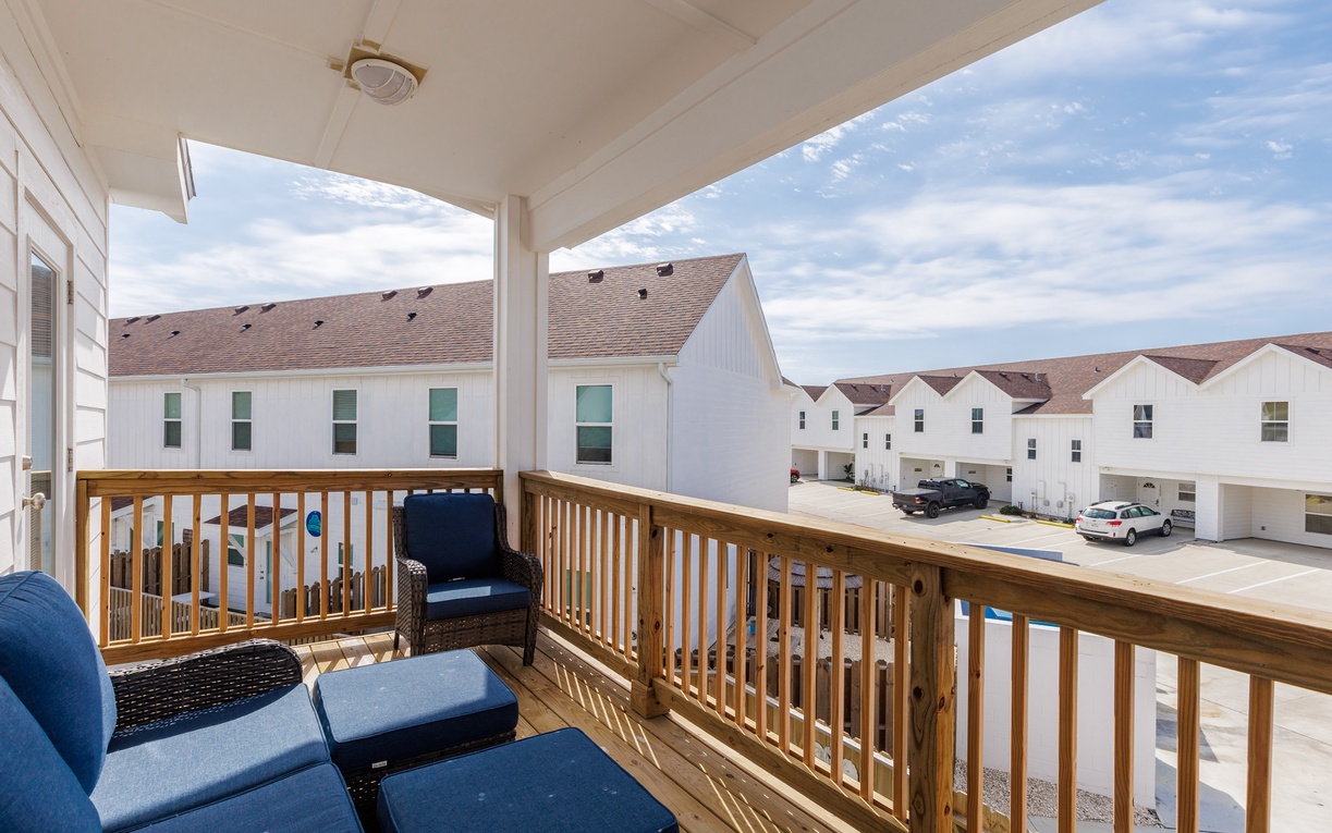Relax on your private covered balcony with comfortable seating and neighborhood views.