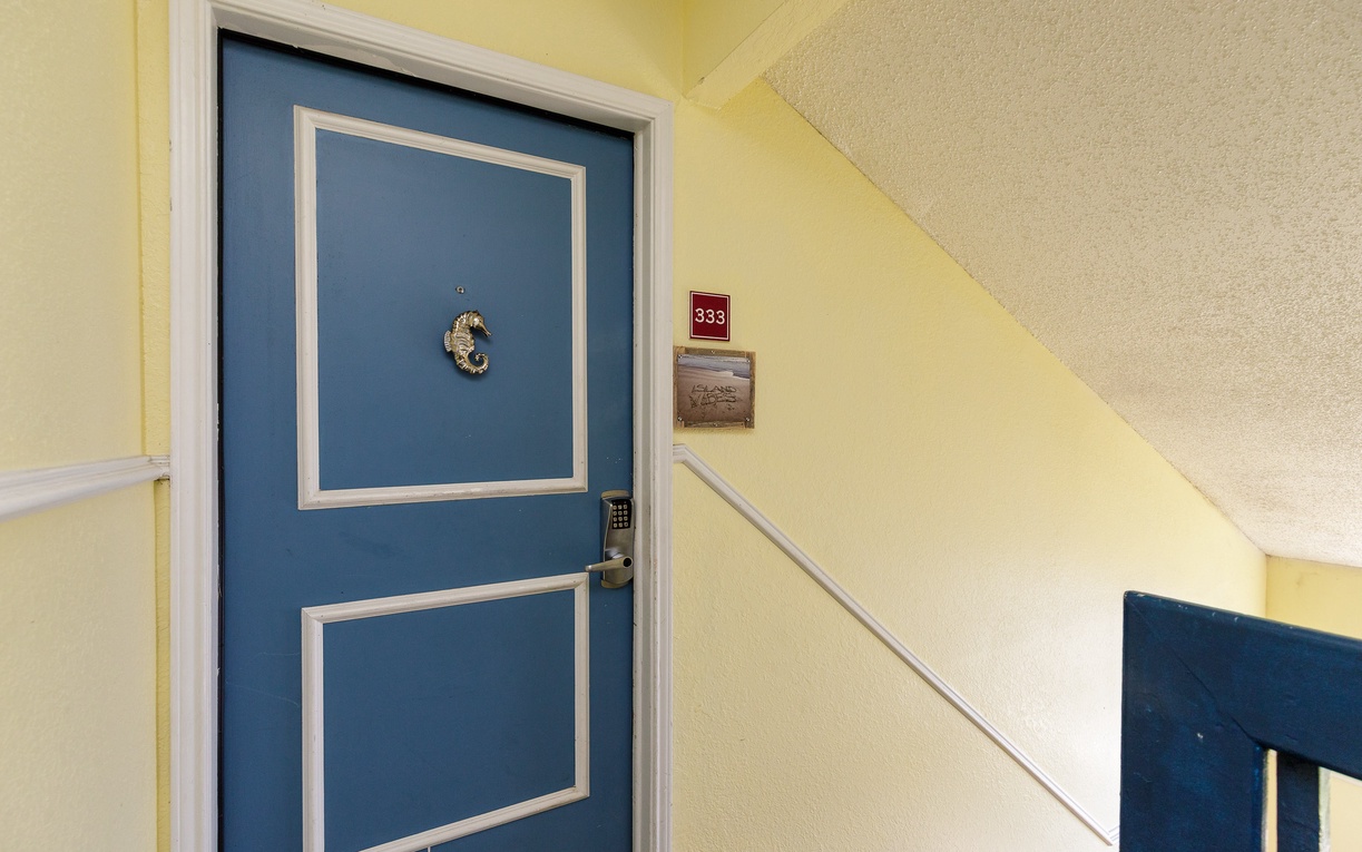 Charming blue door with classic white trim marks the entrance to your cozy retreat, complete with secure keypad entry for easy check-in.