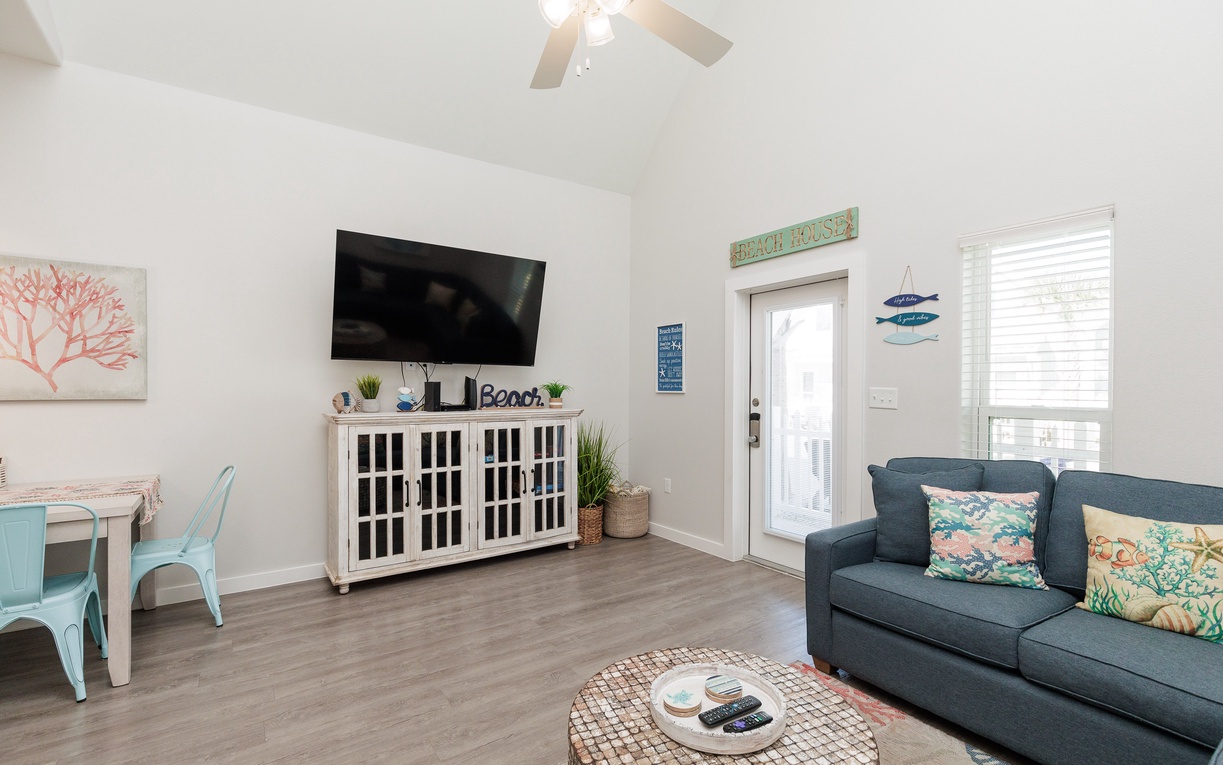 Relax in your bright coastal living room with cheerful beach decor, comfy sofa, and entertainment center for cozy evenings.