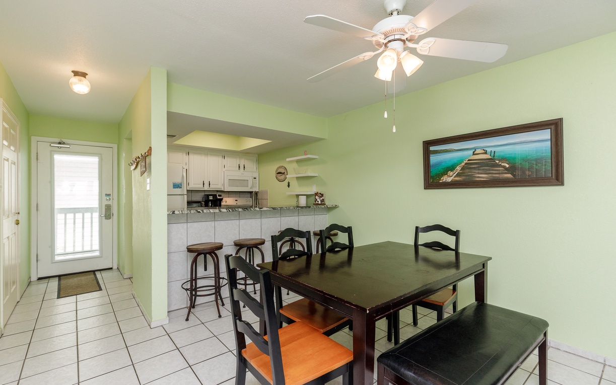 Your bright dining area features a spacious table with seating for six, plus a convenient breakfast bar connecting to your fully equipped kitchen.