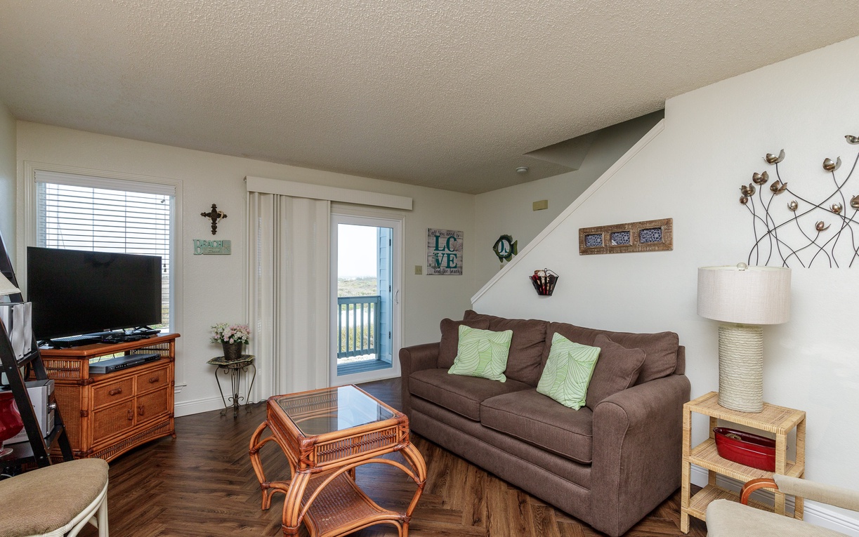 Unwind on your plush sofa while enjoying coastal views through sliding doors that open to your private balcony.