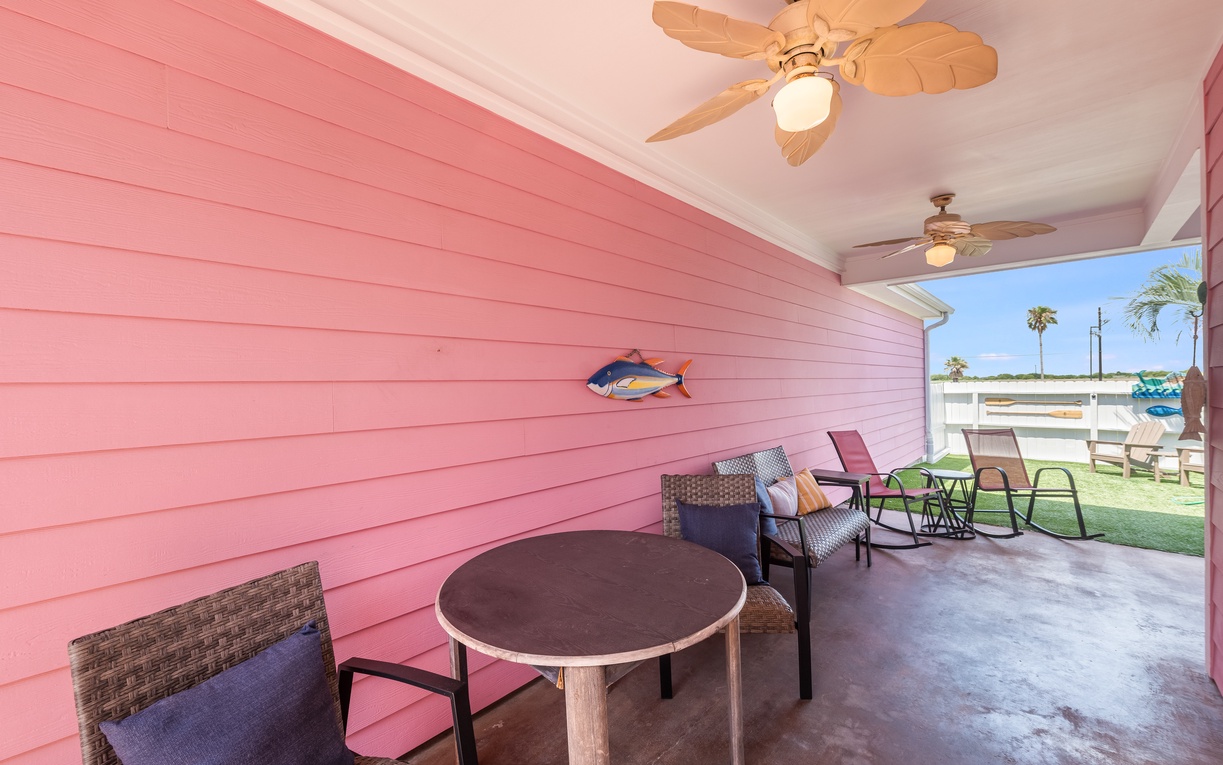 Relax on your covered patio with comfortable seating and tropical ceiling fans, while enjoying views of the sunny outdoor space beyond.