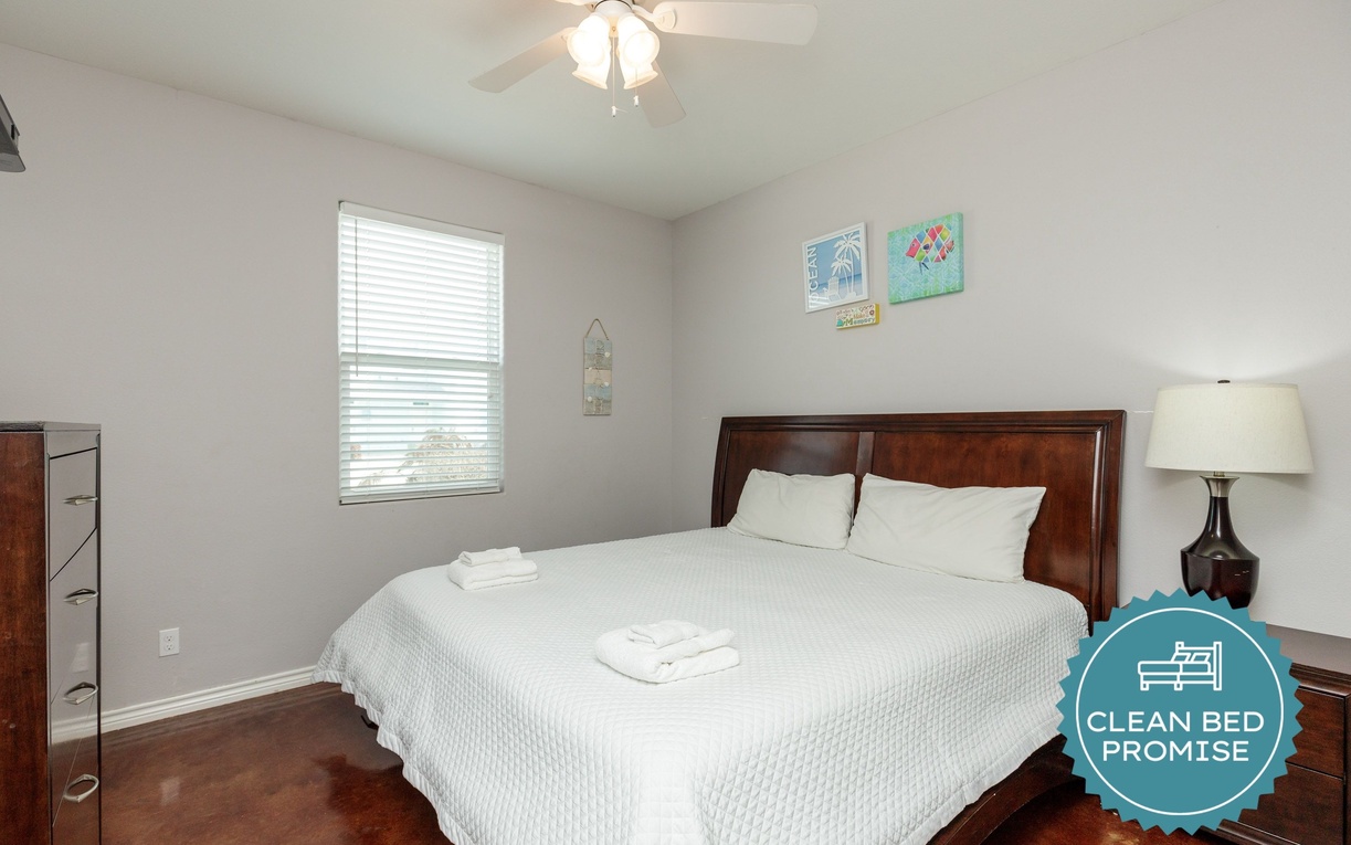 Sink into crisp white linens on your comfortable king bed, where gentle morning light filters through blinds for perfect rest.