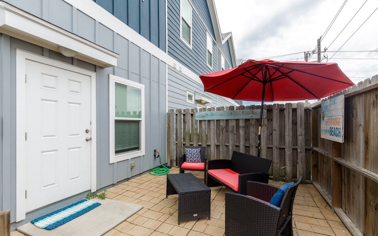 Your private patio offers cozy outdoor seating with red umbrella shade, perfect for morning coffee or evening relaxation.