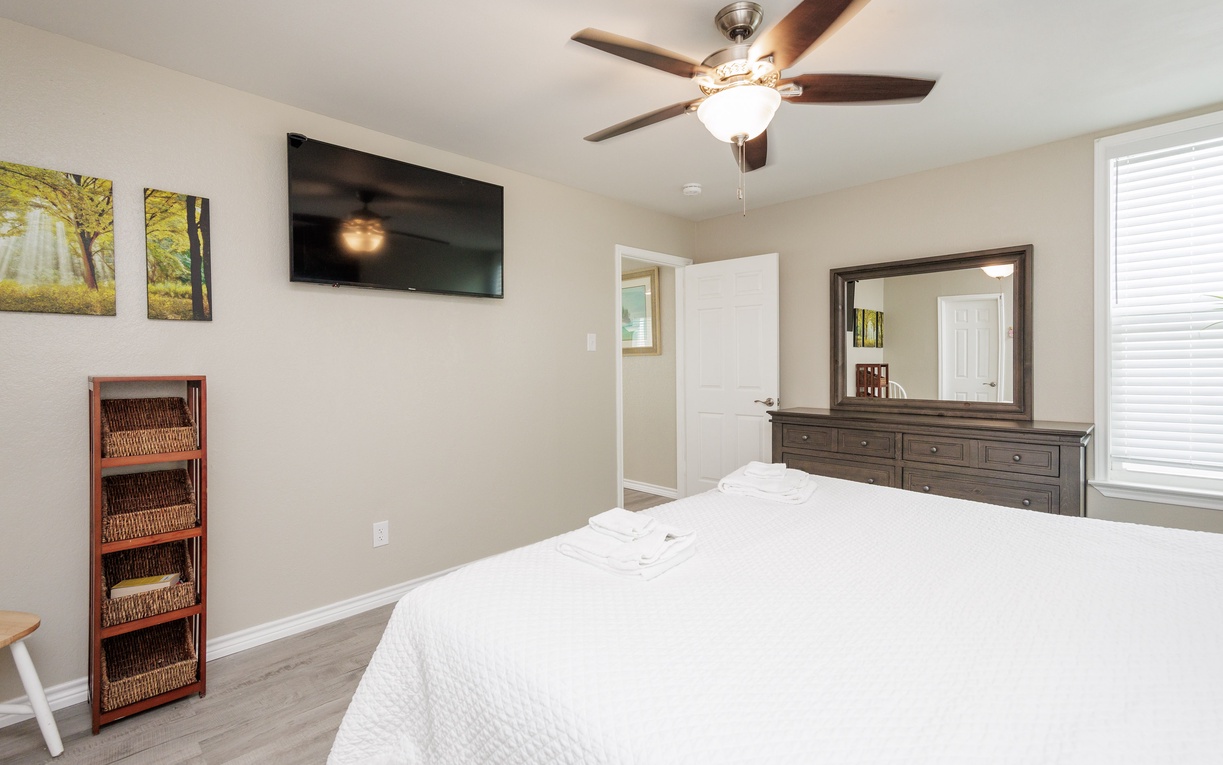 Unwind in your peaceful bedroom featuring a king size bed, warm decor, and modern amenities for ultimate comfort.