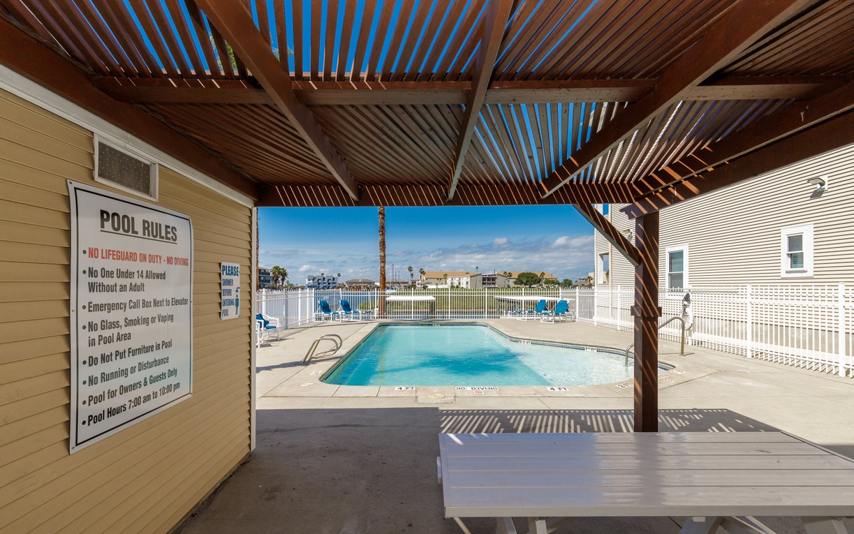 Step into your private poolside oasis with crystal-clear waters and comfortable lounging areas under beautiful pergola shade.