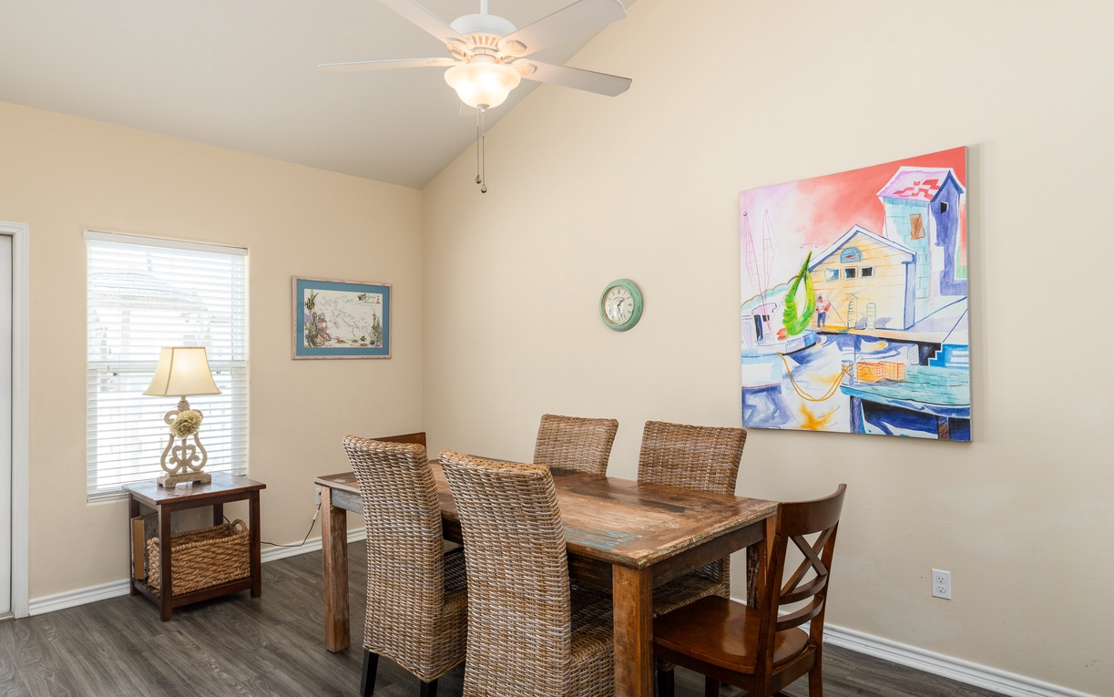 Your spacious dining room welcomes family meals with comfortable seating for six and charming coastal artwork overhead.